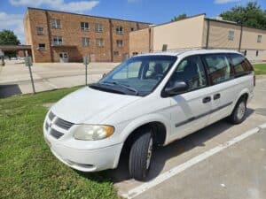 Side of White Dodge Mini Van, some rust
